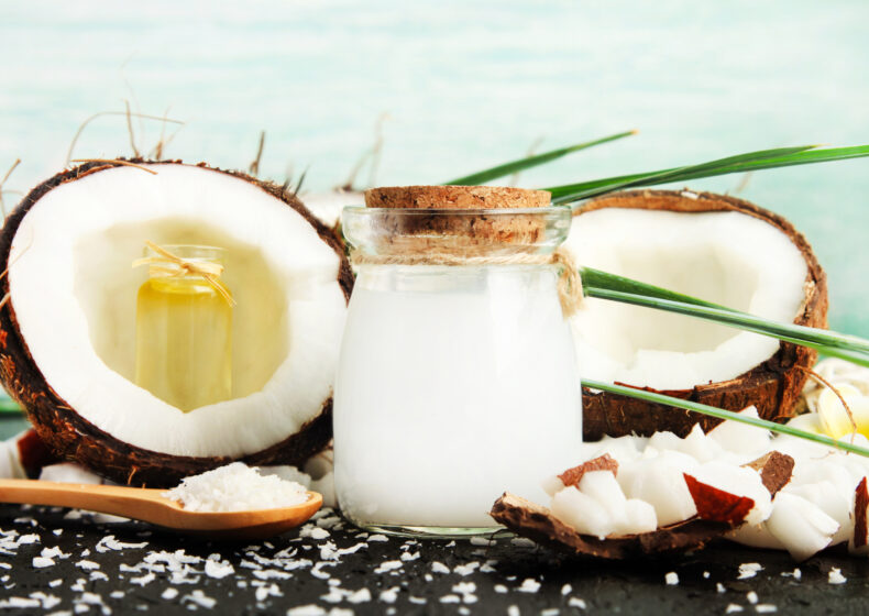 Coconuts with jar of Coconut Milk and Spoon full of Coconut Oil